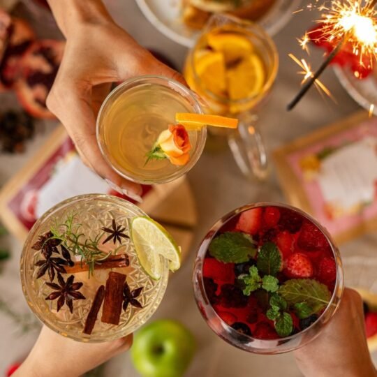 Taças de cristal com drinks Iced Teas gelados de chá e frutas sobre mesa posta